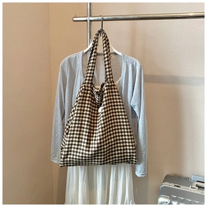 Close-up of a large-capacity checkered tote bag in brown and beige hanging in a closet