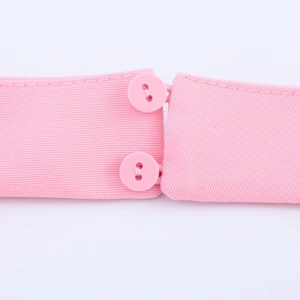Nahaufnahme des rosa Neckholder-Midikleides mit Fokus auf Strickstoff und Knopffunktionen