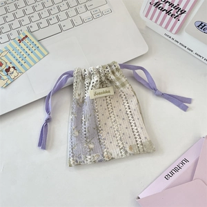 Vue détaillée du sac de rangement en dentelle avec ruban violet et étiquette tissée