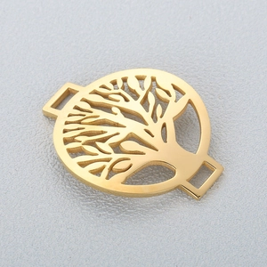 Macro shot of golden Tree of Life jewelry connector charm with cutout design