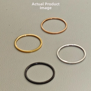 Flat lay of four minimalist thin titanium steel rings in gold silver black and rose gold