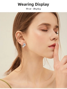 Close-up of elegant six-prong moissanite stud earring on ear with S925 silver base