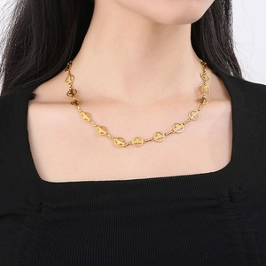 Détail du collier en acier titane doré avec des maillons circulaires motif colombe