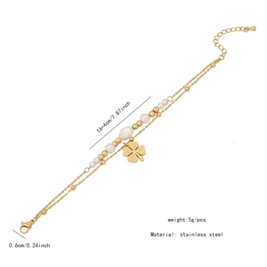 Détail du bracelet double couche en acier inoxydable doré avec trèfle et breloques perles