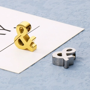 Macro shot of gold and silver ampersand metal charms for DIY jewelry making and crafts