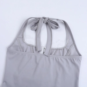Détail d'un haut dos nu gris clair avec dentelle blanche et fermeture à crochet au dos