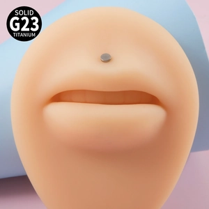 Solid G23 titanium teardrop labret stud shown on model with blue and pink background