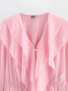 Détail du chemisier en mousseline rose avec col en V et volants superposés élégants