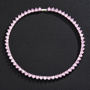 Close-up of pink heart-shaped crystal tennis chain necklace on black leather