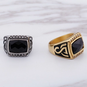 Detailed view of silver and gold hip hop rings with black stone and side diamonds
