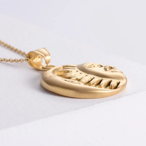 Detailed view of sun and moon vintage 18K gold plated pendant necklace with matte finish