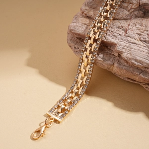Detailed close-up of a luxury gold-plated square bracelet with three rows of pavé diamonds