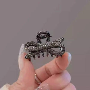 Close-up of small bow hair claw clip in gunmetal finish with sparkling rhinestones
