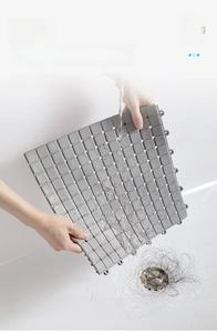 Close-up of grey TPE interlocking bath mat showing water drainage and hair filtration
