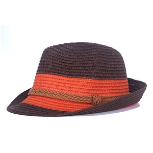 Close-up of brown straw fedora hat featuring orange ribbon detail and woven texture