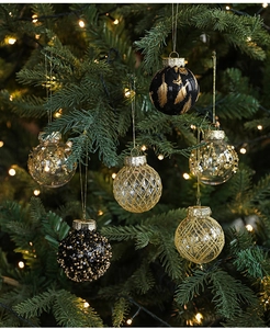 Detail of luxury 5cm black and gold Christmas ornaments hanging on a festive tree