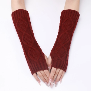Detail of red cable-knit fingerless gloves showing textured knit pattern and arm length