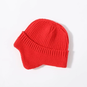 Close-up of red knit earflap hat with thick wool texture and warm winter lining