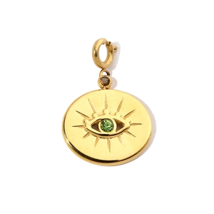 Detailed close-up of golden round Evil Eye pendant featuring a green crystal inlay