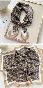 Detail of silk-like satin square scarf featuring brown paisley patterns and smooth texture