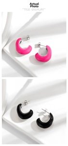 Detail view of C-shaped stainless steel enamel earrings in bright pink and black