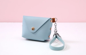 Detailed view of light blue leather envelope coin purse with metallic stud and wrist strap