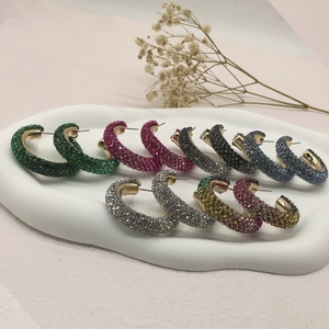 Colorful rhinestone C-shaped hoop earrings set with crystal inlay on a white tray