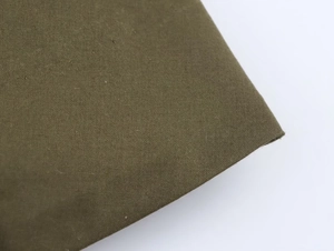 Détail de la texture plissée du tissu tissé vert olive de la robe midi