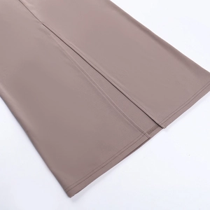 Detailed close-up of high-density knit dress hem featuring clean stitching and central slit