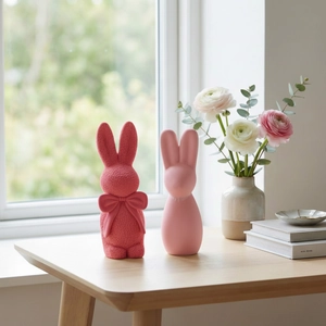 Detailansicht von rosa strukturierten und glatten Mini-Hasenfiguren auf einem Holztisch