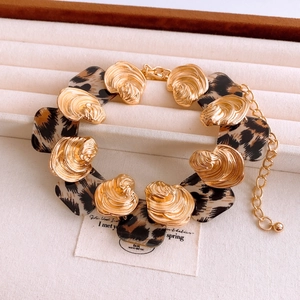 Detail of vintage gold shell bracelet with leopard print resin inserts on display