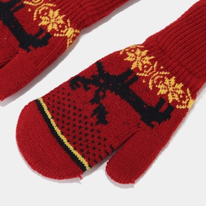 Close-up of red knitted mittens with festive elk jacquard and snowflake patterns