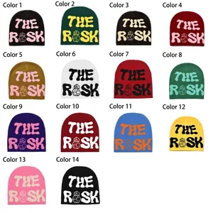 Grid display of 14 different colors of THE RISK jacquard knit beanies with dice pattern