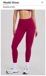 Detail view of raspberry red high waist yoga pants showing matte stretch fabric on model