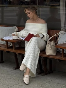 Close-up of white off-shoulder knitted dress featuring elegant ribbed texture details