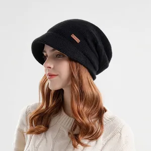 Dames zwarte gebreide muts met klep, warme fleecevoering en lederen logo detail
