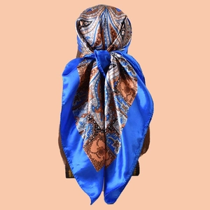 Detail of vintage paisley silk scarf with blue border shown on a display mannequin