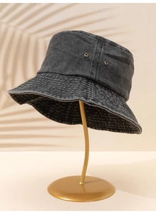 Détail du bob en denim délavé gris foncé avec œillets d'aération métalliques sur support