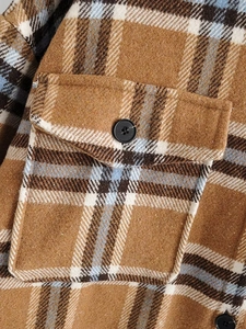 Gros plan d'un manteau en flanelle à carreaux marron et bleu avec poche à rabat