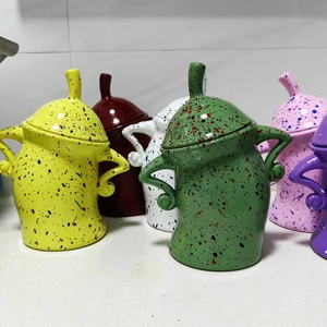 Close-up of ceramic canisters with attitude featuring unique hands-on-hips shapes