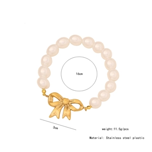 Detail shot of pearl bracelet with golden bow pendant showing 16cm diameter and 11.5g weight