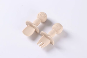 Close-up of baby training silicone spoon and fork set with short ergonomic wooden handles