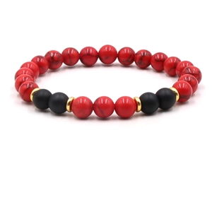 Detail of beaded bracelet with red marble texture, matte black beads and gold spacers
