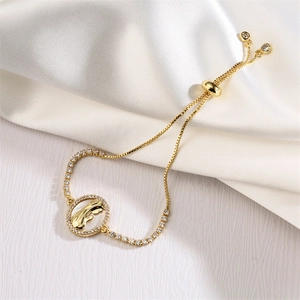 Detail of adjustable gold rabbit bracelet featuring a shell inlay and cubic zirconia stones