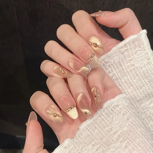 Detailed view of handmade cat-eye press-on nails with champagne gold rhinestones