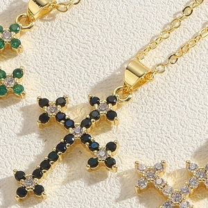 Macro detail of gold-plated cross pendant with colorful zircon stones inlay on necklace