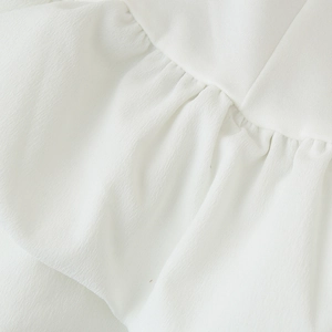 Haut blanc pour femme à volants avec texture plissée délicate et design dos nu chic
