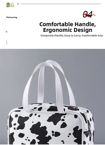 Close-up of makeup bag showing cow pattern print and durable white PU handle detail