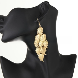 Detailed close-up of layered golden leaf tassel earrings with fine vein textures