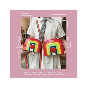 Detailed view of rainbow crossbody bags with red heart accent and striped straps